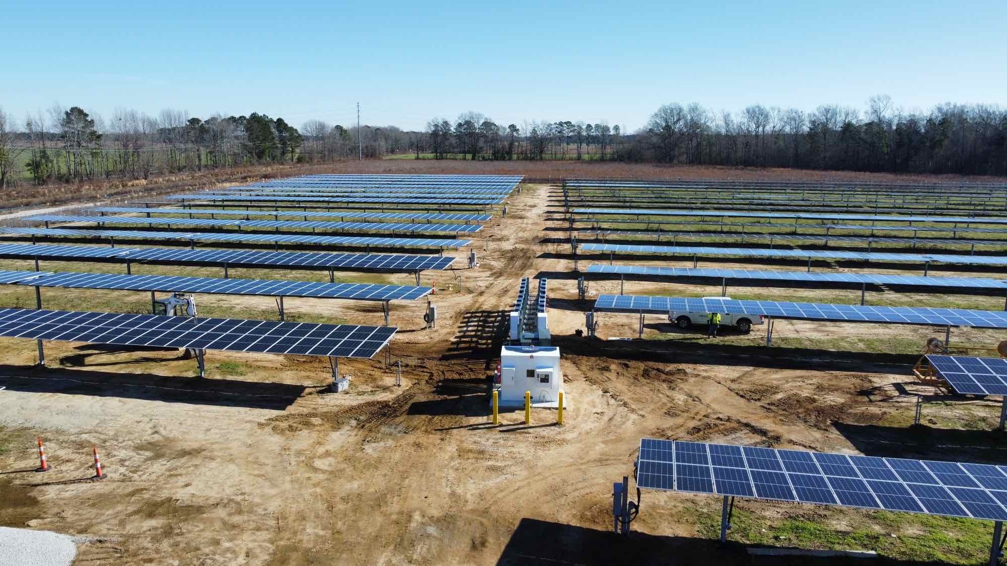 Aerial view of a completed utility-scale solar installation at sunset